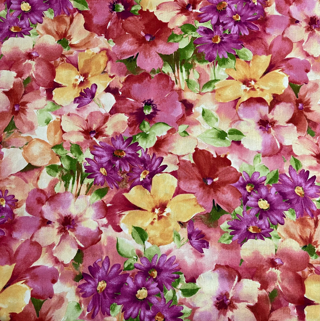 Floral fabric with pink, purple, and yellow flowers on a green cutting mat.