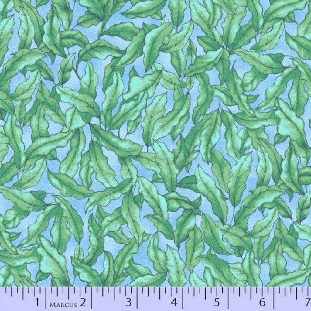 Fabric with green leaf pattern on a blue background, featuring a ruler at the bottom.