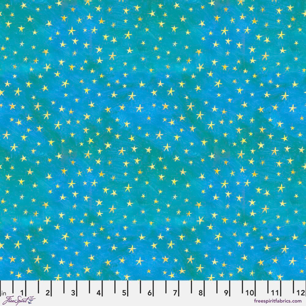 A fabric featuring a pattern of small gold stars on a teal blue background with a ruler at the bottom for scale.