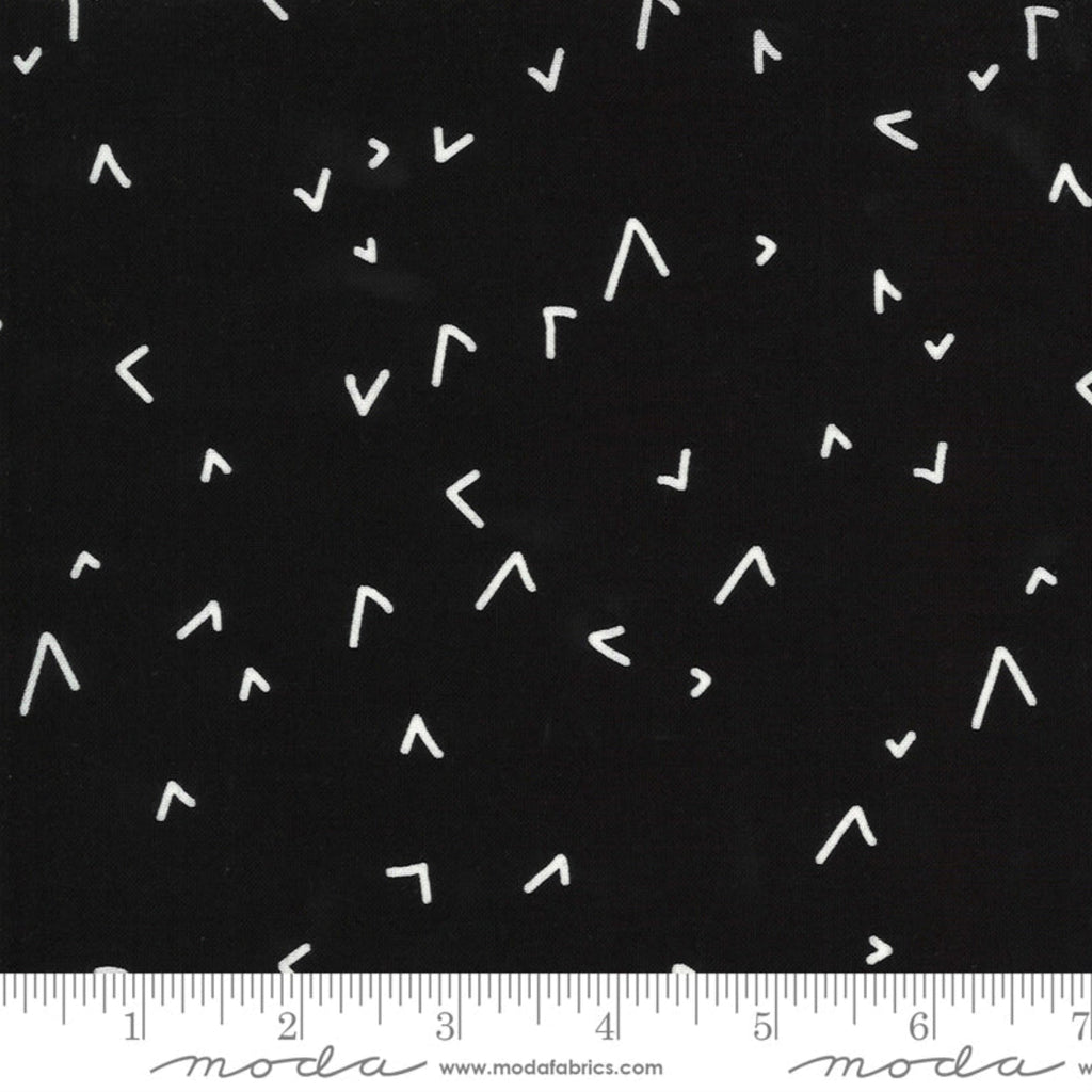 A fabric with a geometric pattern in black and white, showing various shapes such as triangles and straight lines, indicating a design by Zen Chic.