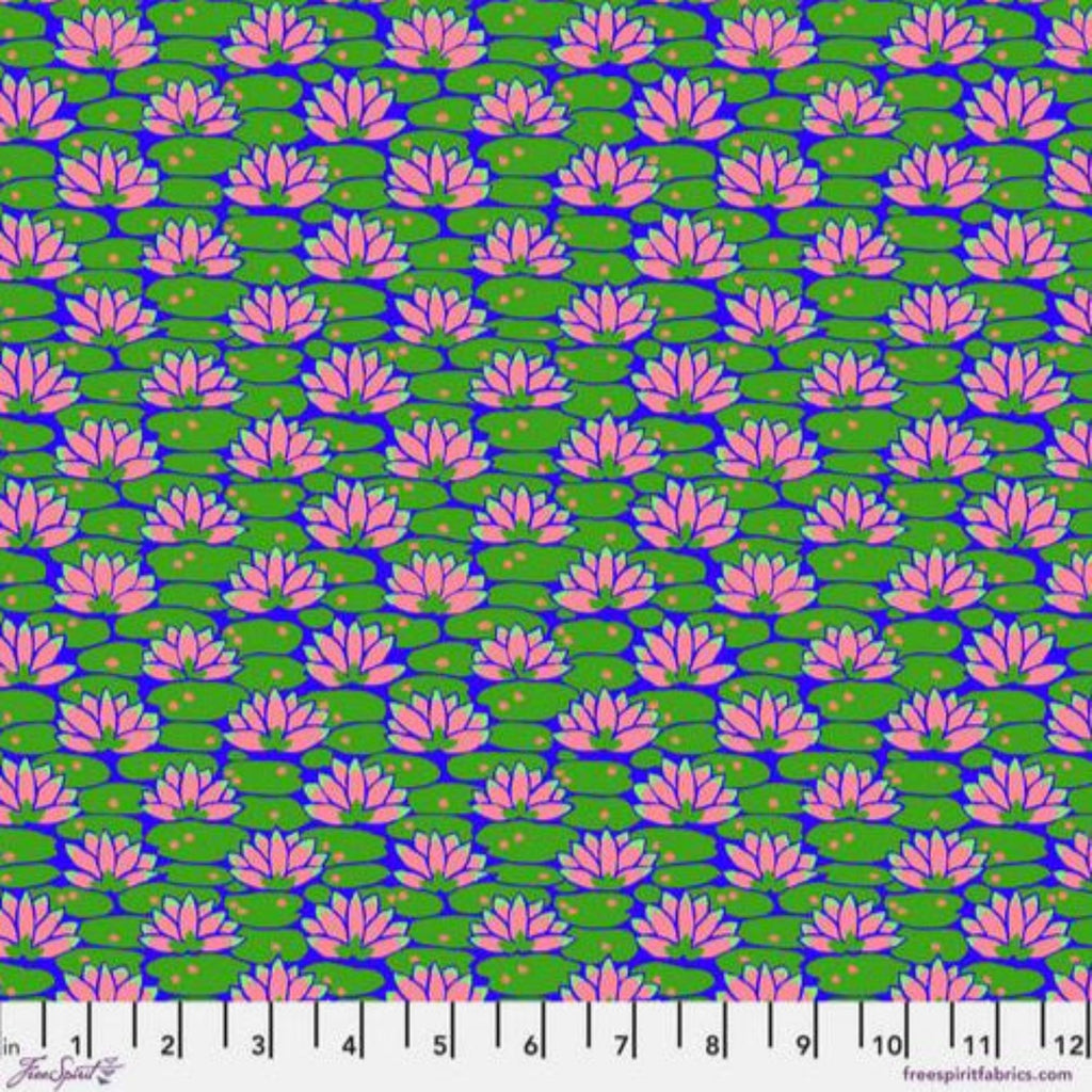 A fabric featuring a floral pattern with pink lily-like flowers on a green background, marked with a measuring scale at the bottom.