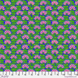 A fabric featuring a floral pattern with pink lily-like flowers on a green background, marked with a measuring scale at the bottom.
