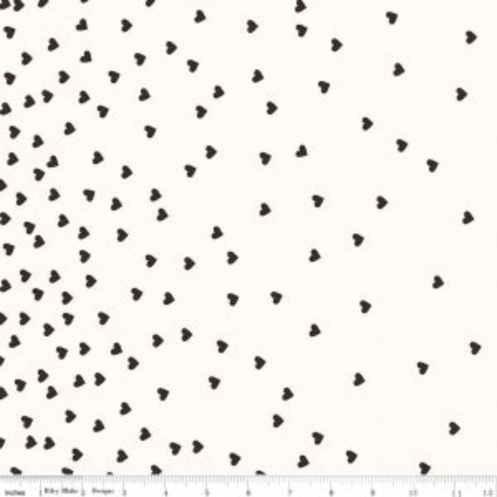 A fabric featuring a white background with a scattered black heart pattern, measuring 112cm in width.