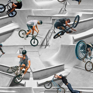 A patterned fabric featuring multiple images of BMX bikers performing tricks in a skatepark.