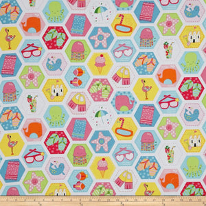 Colorful fabric pattern with various items in hexagonal shapes on a ruler for scale.