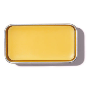 Rectangular tin with a yellow bar of soap on a white background