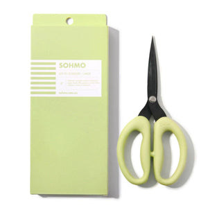 Green scissors with a matching green packaging box on a white background