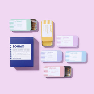 Collection of SOHMO product packaging on a pink background