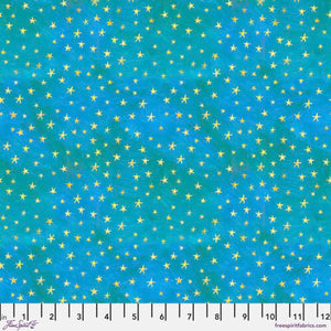 A fabric featuring a pattern of small gold stars on a teal blue background with a ruler at the bottom for scale.