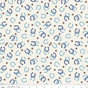 A fabric featuring a pattern with blue horseshoes and brown accents on a white background, with a ruler at the bottom for scale.